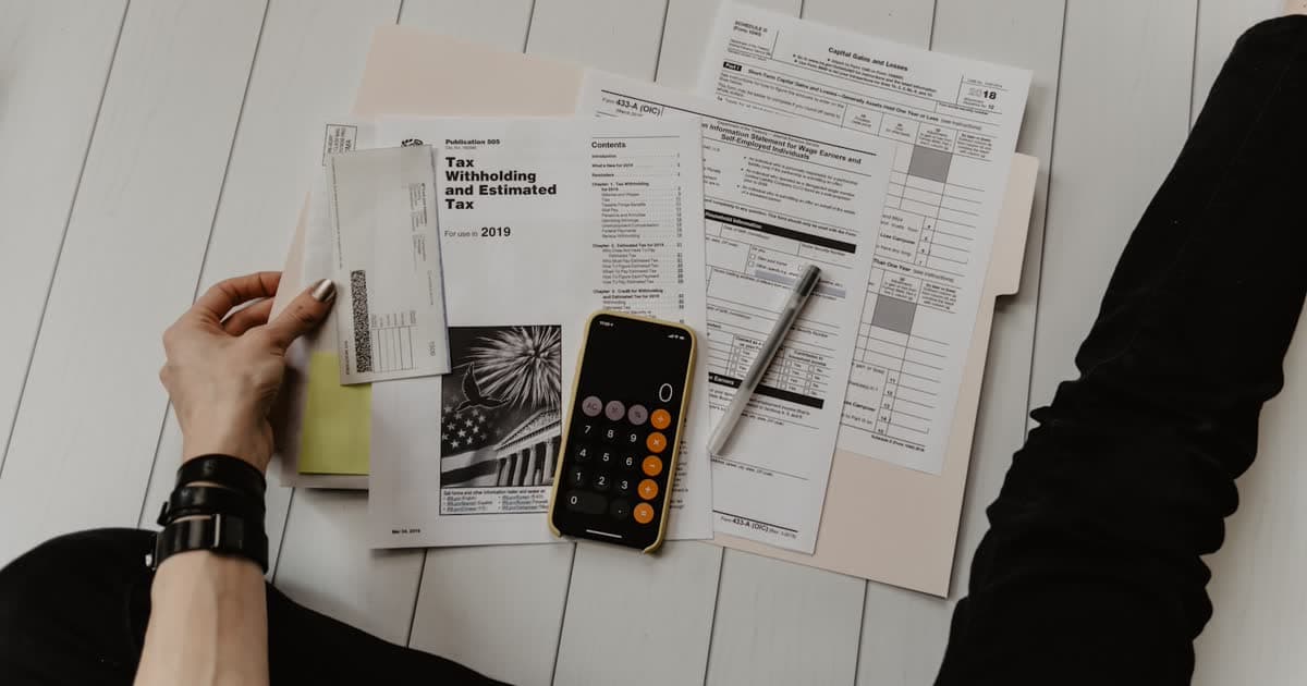 Desk with calculator and charts suggesting careful budget planning for AI agent work
