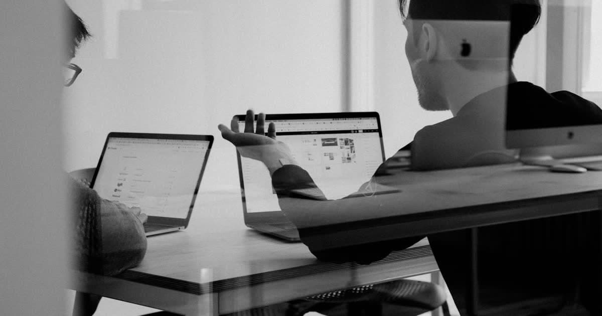 Team reviewing work together at a desk, symbolizing human approval in AI agent workflows